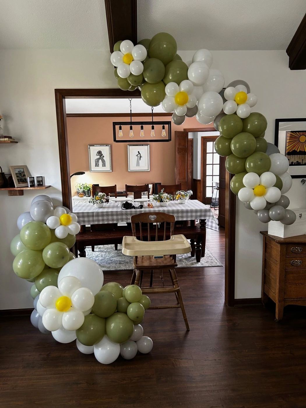 Olive, white and daisy balloon garland around a doorway