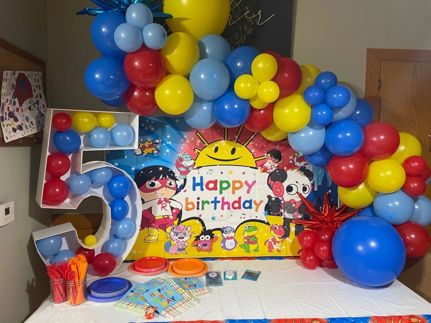 Fifth birthday balloon arch over a table